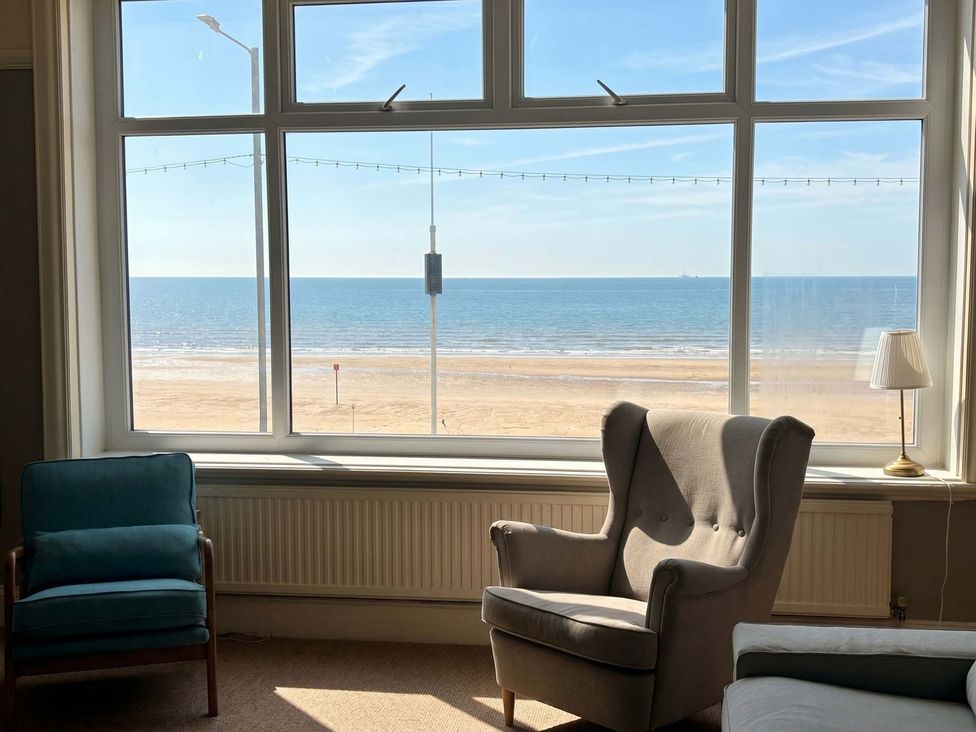 A living room with a view of the beach and sea at Sunrise Lodge in Bridlington