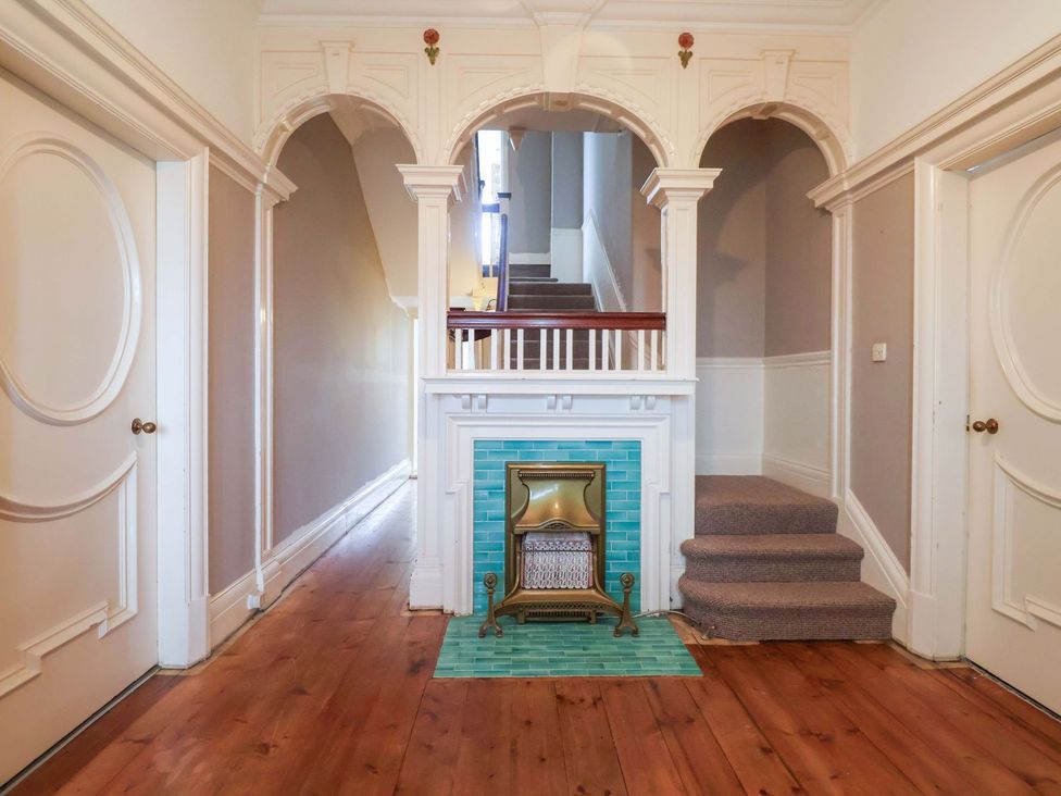 A hallway with a staircase and fireplace at Sunrise Lodge in Bridlington