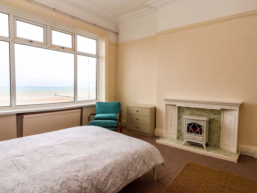 A bedroom with a bed and a view of the sea at Sunrise Lodge in Bridlington