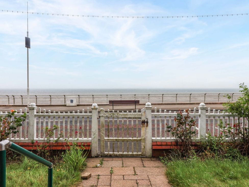 A view of the sea from a garden with a gate at Sunrise Lodge in Bridlington