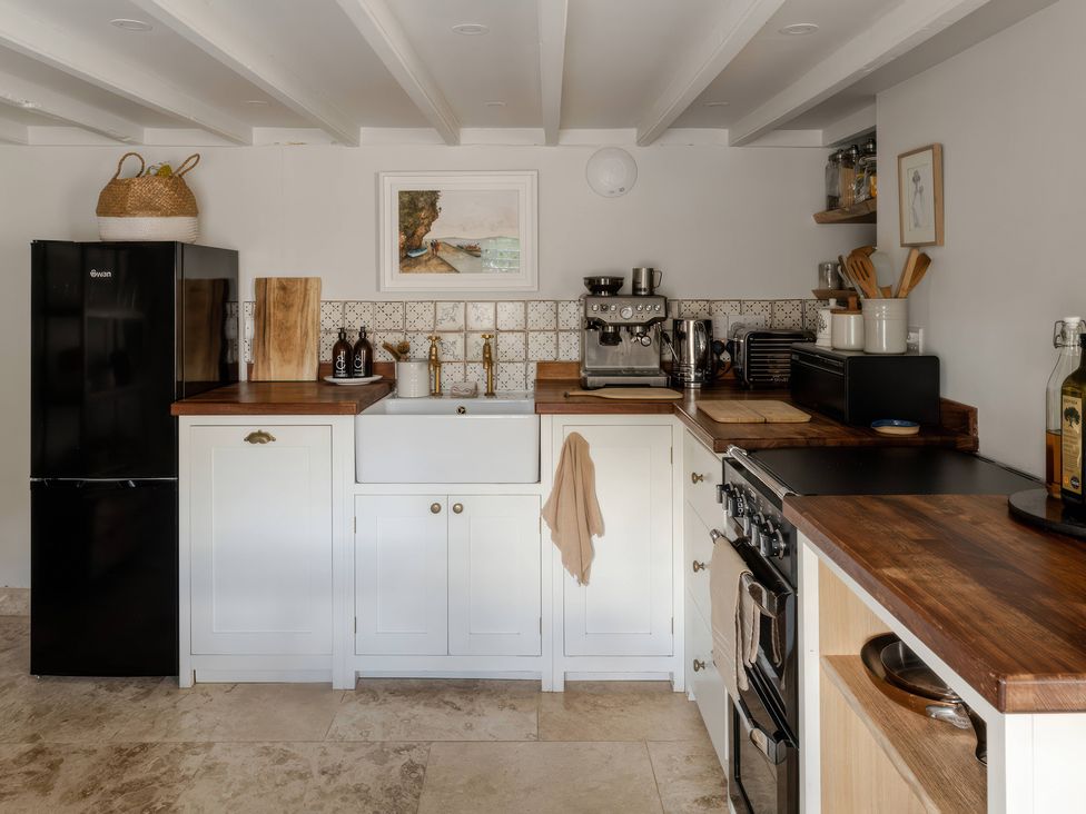 A kitchen with a sink and refrigerator at Rose Cottage in Gweek