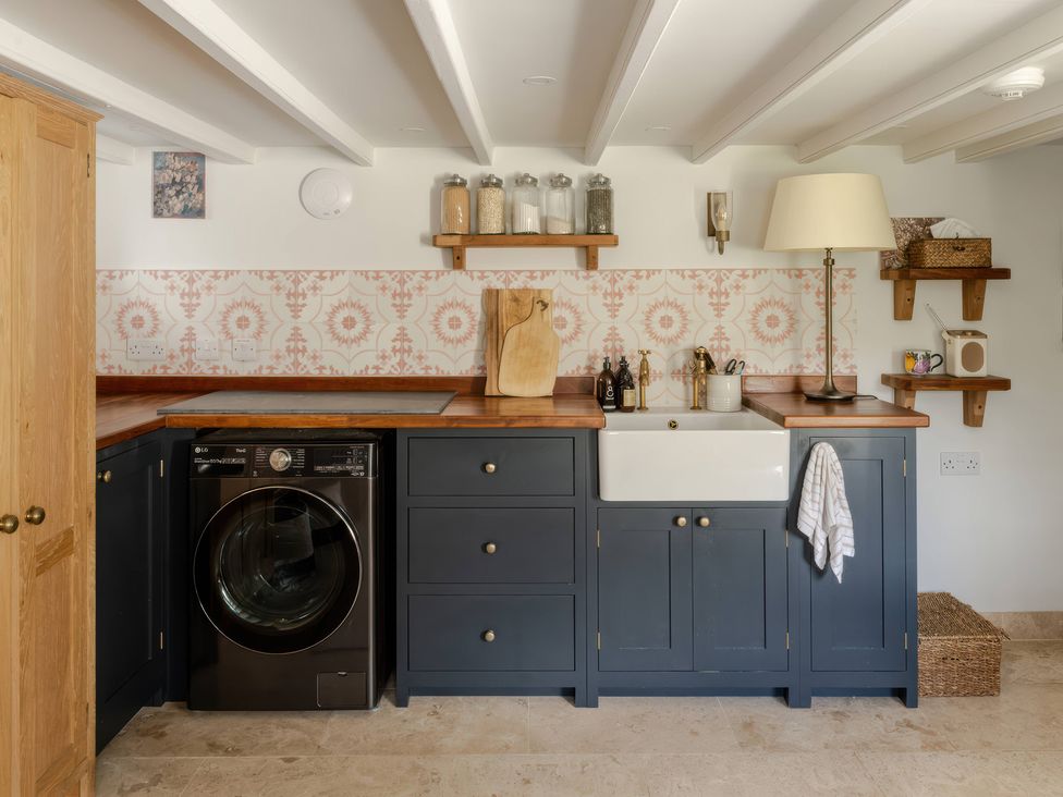 A kitchen with a washing machine and a sink at Rose Cottage in Gweek