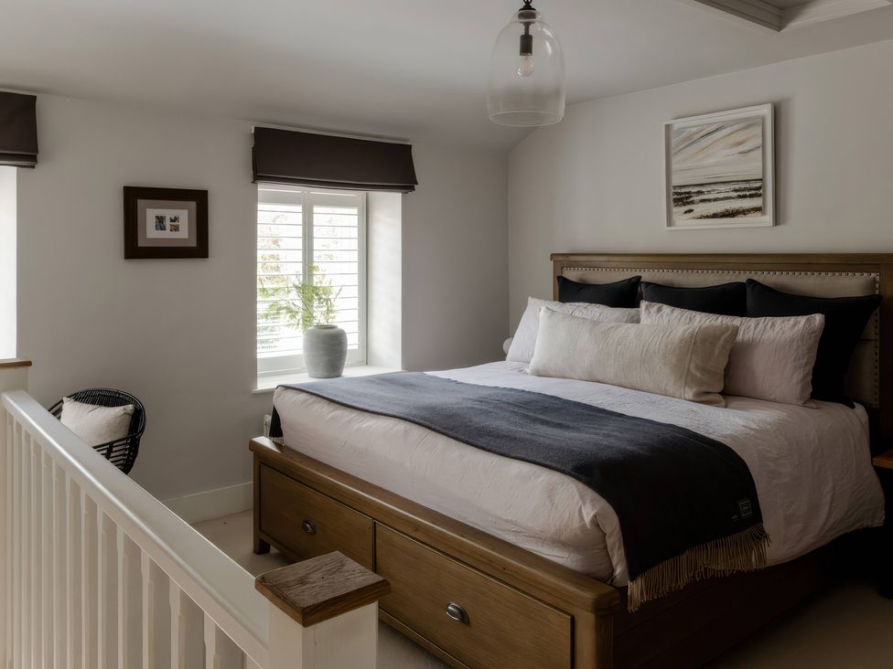 A bedroom with a bed and window at Rose Cottage in Gweek