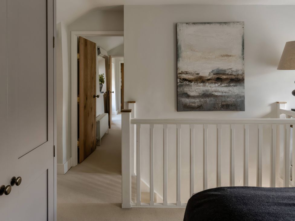 A hallway with doors and artwork at Rose Cottage in Gweek