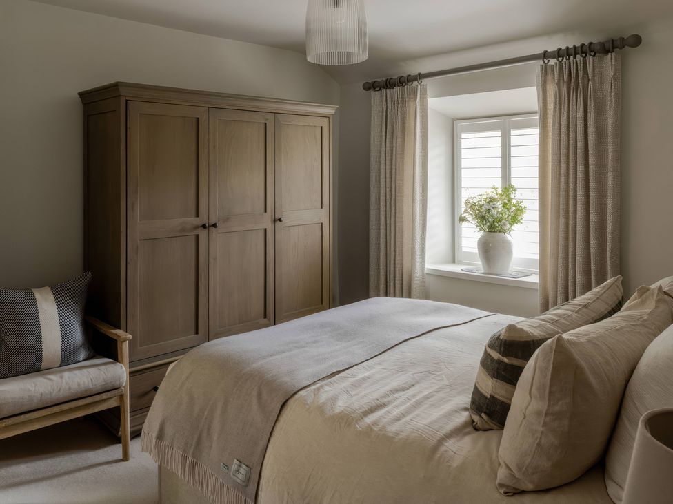 A bedroom with a bed and wardrobe at Rose Cottage in Gweek