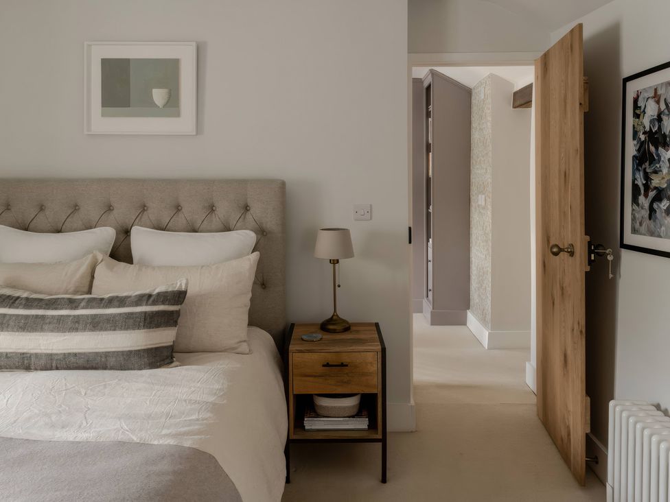 A bedroom with a bed and bedside table at Rose Cottage in Gweek