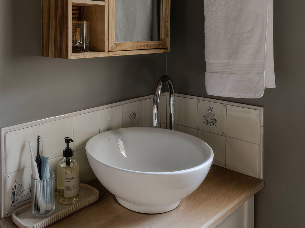 A bathroom with a sink and accessories at Rose Cottage in Gweek