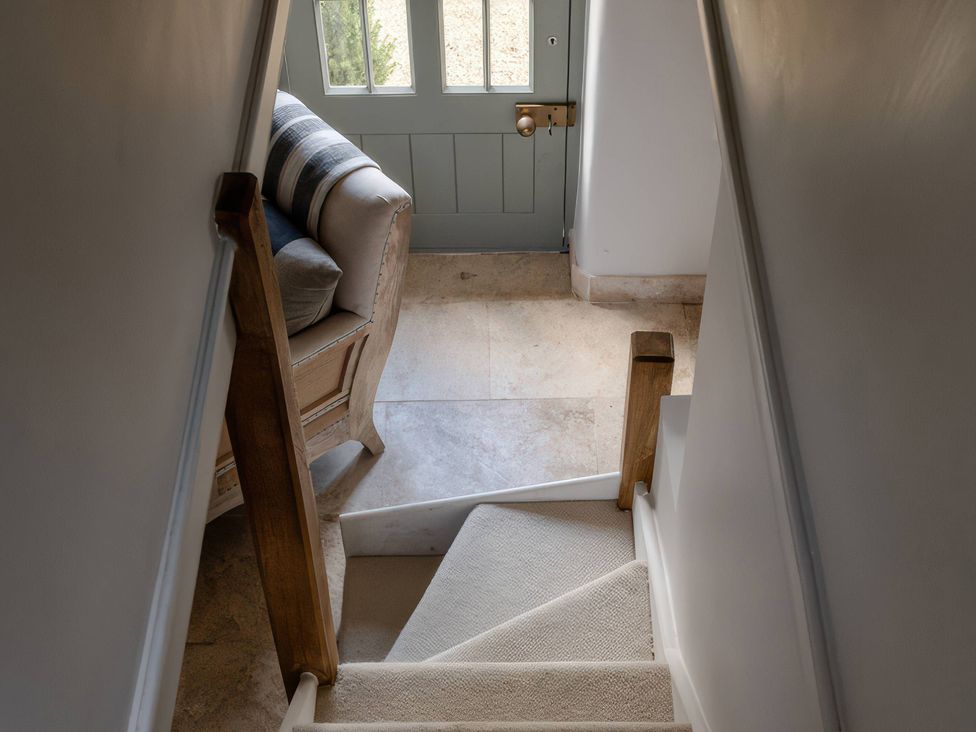 A hallway with a staircase and a door at Rose Cottage in Gweek
