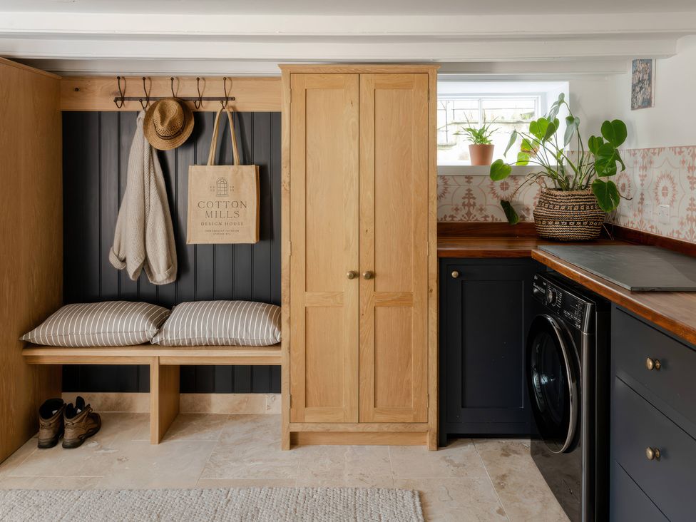 A utility room with a washing machine and storage at Rose Cottage in Gweek