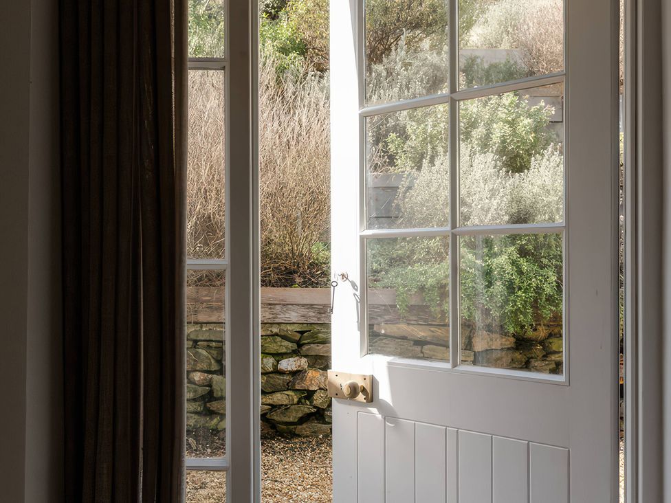 A door opening to a garden view at Rose Cottage in Gweek