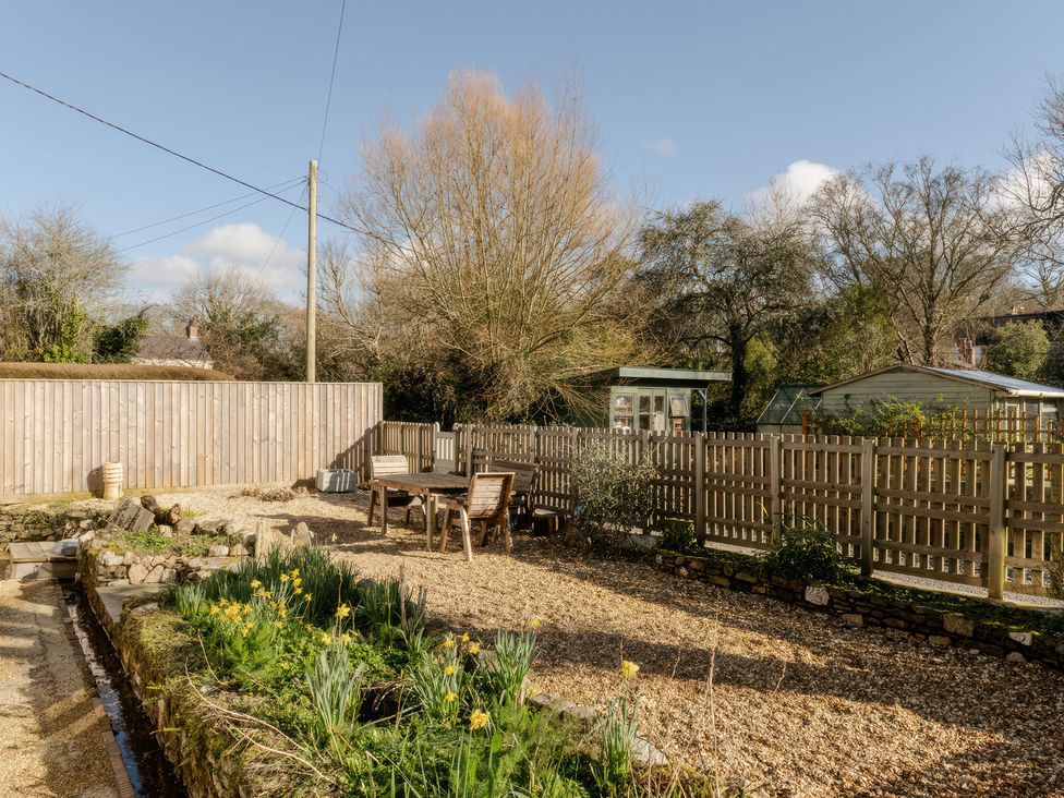 A garden with a table and chairs at Rose Cottage in Gweek