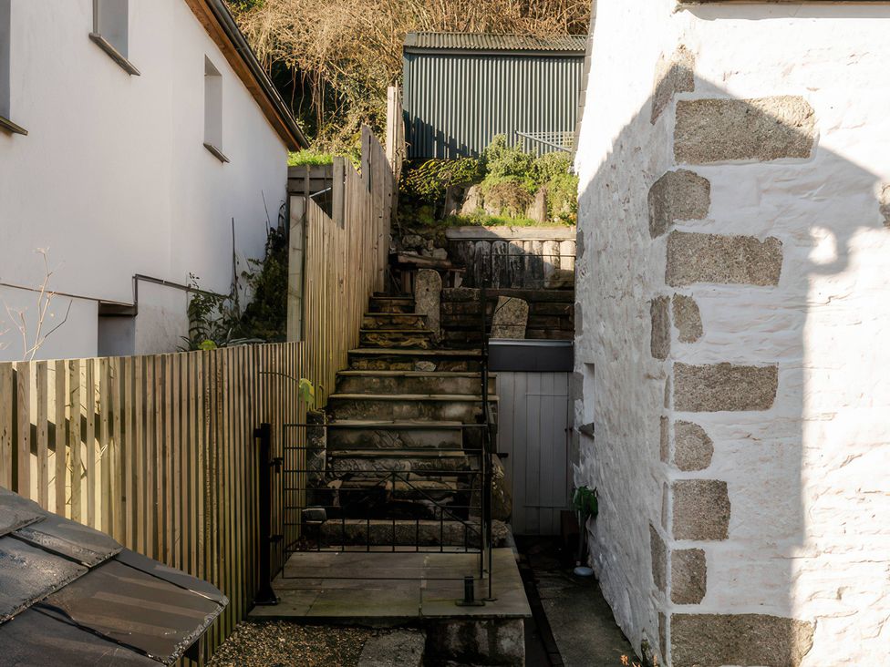 An outdoor space with stairs and walls at Rose Cottage in Gweek