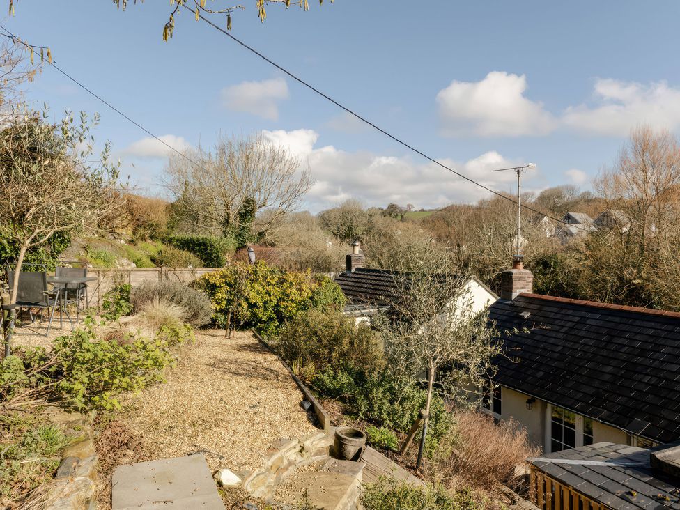 A garden with gravel paths and seating area at Rose Cottage in Gweek