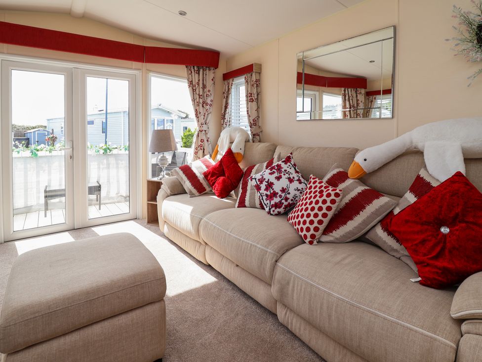 A living room with a sofa and pillows at 15 Elm Crescent in Rhyl