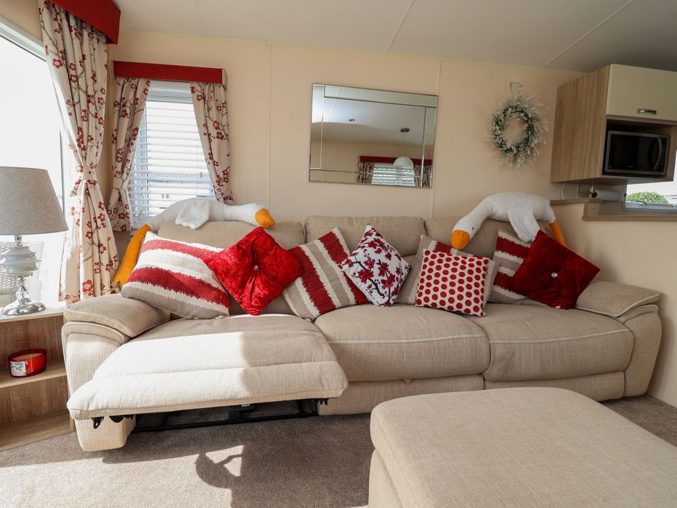 A living room with a sofa and pillows at 15 Elm Crescent in Rhyl