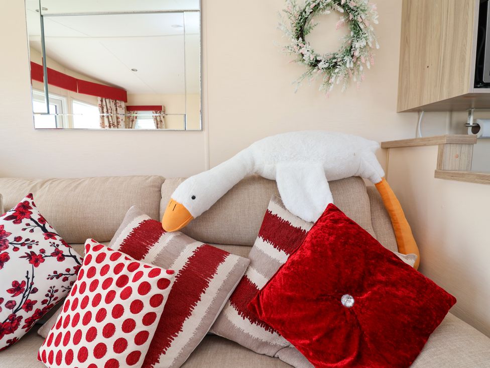 A living room with a sofa and cushions at 15 Elm Crescent in Rhyl