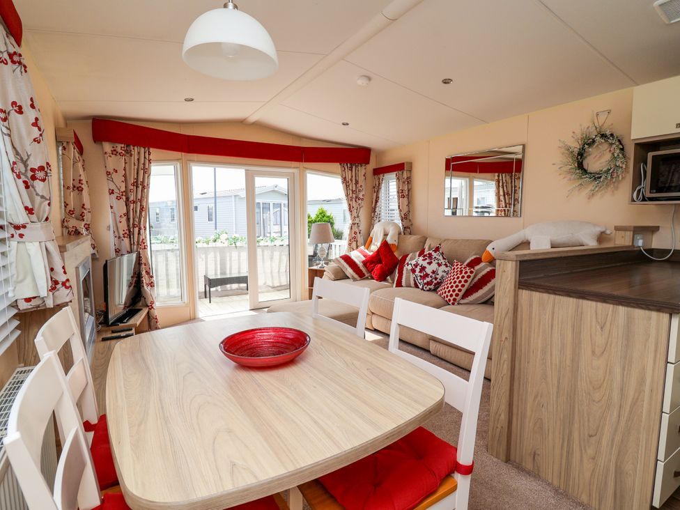 A living room with a dining area and large windows at 15 Elm Crescent Rhyl