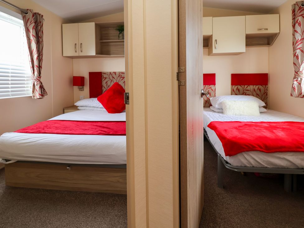 A bedroom with two beds and a window at 15 Elm Crescent in Rhyl