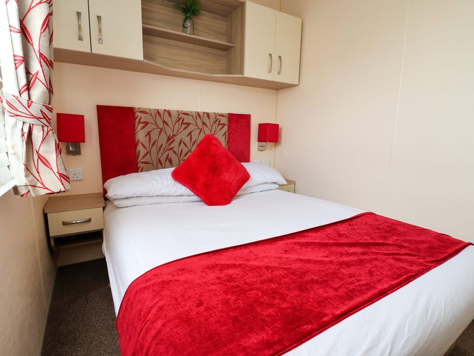 A bedroom with a bed and nightstand at 15 Elm Crescent Rhyl