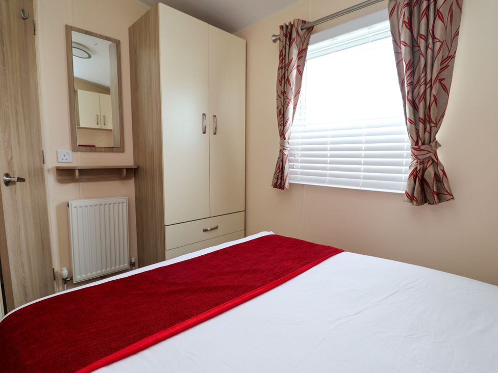A bedroom with a bed and wardrobe at 15 Elm Crescent in Rhyl