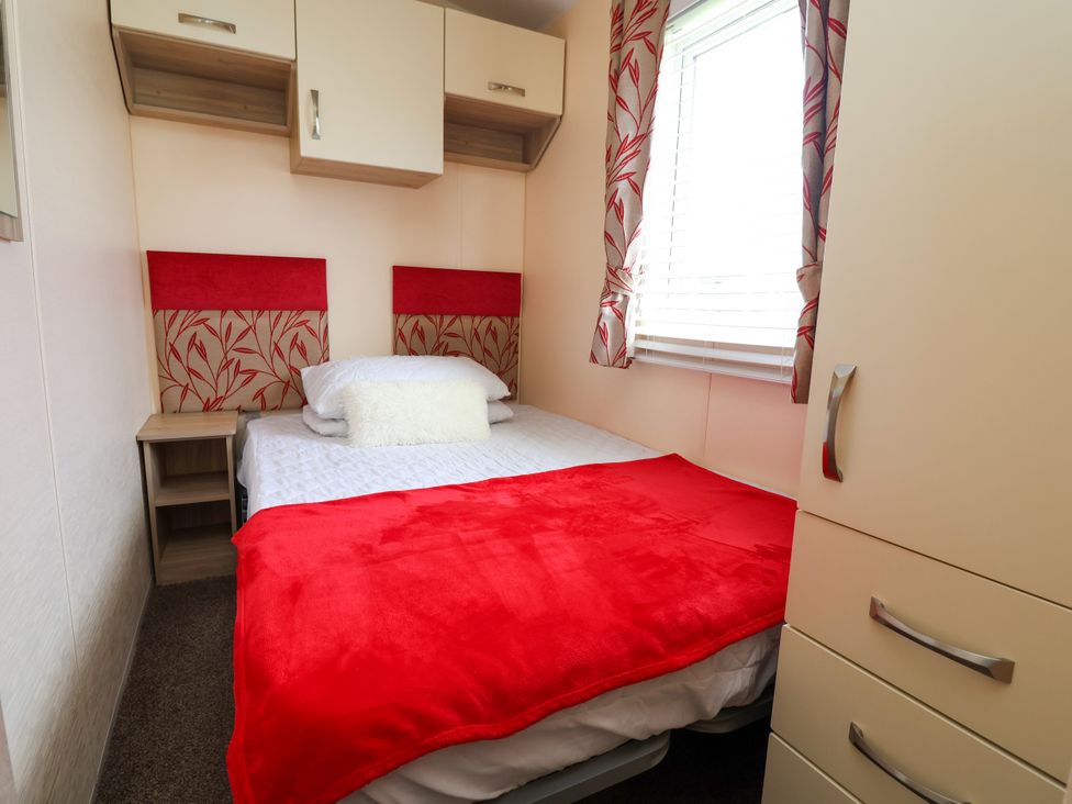 A bedroom with a bed and a wardrobe at 15 Elm Crescent in Rhyl