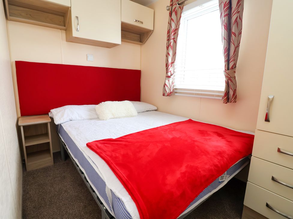 A bedroom with a bed and dresser at 15 Elm Crescent, Rhyl