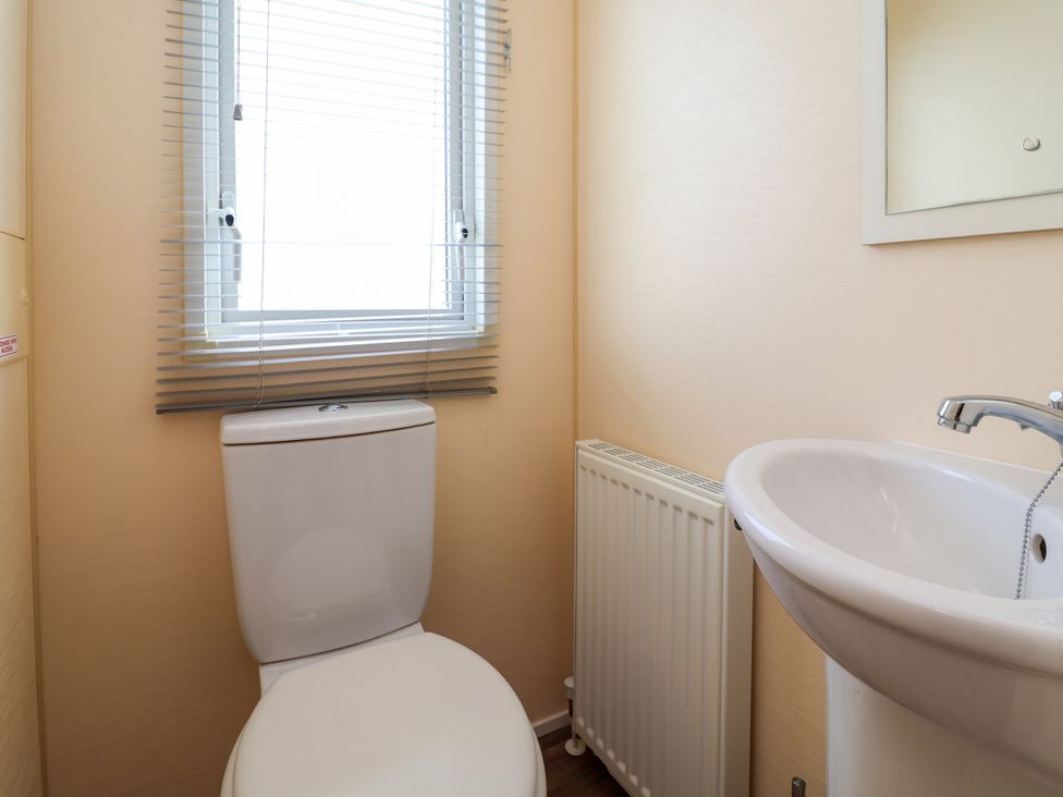 A bathroom with a toilet and sink at 15 Elm Crescent in Rhyl