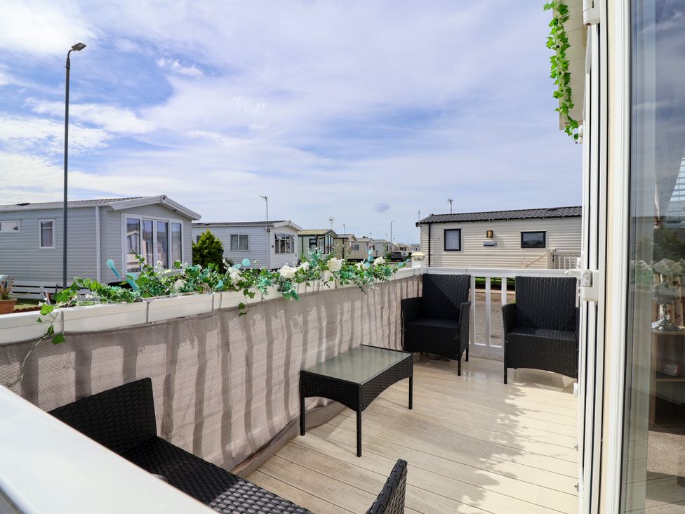 A balcony with chairs and a table at 15 Elm Crescent in Rhyl