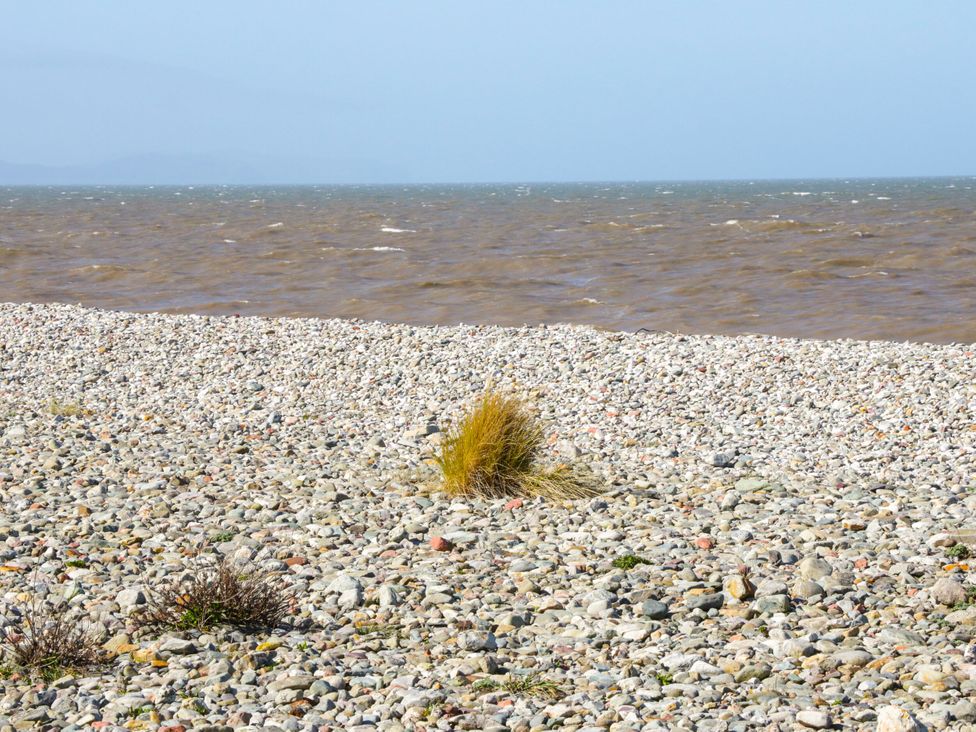 A shoreline with gravel and grass at Tidal Retreat in Rhyl
