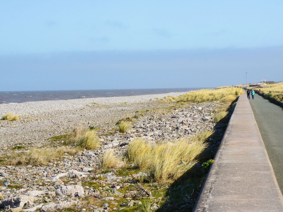 A beach with a pathway and rocks at Tidal Retreat in Rhyl