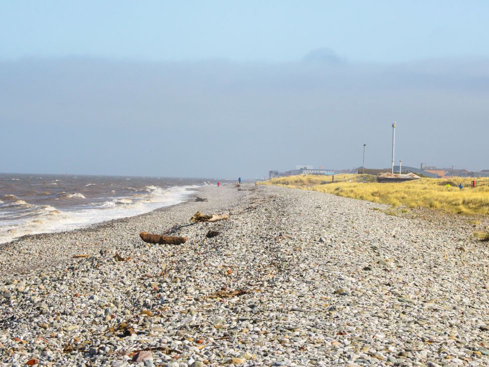 A beach with pebbles and water at Tidal Retreat in Rhyl