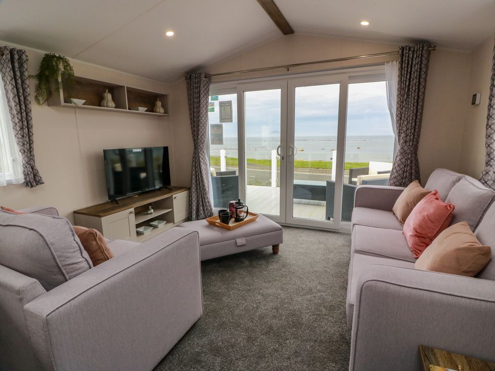A living room with a television and sofa at Caravan in Girvan