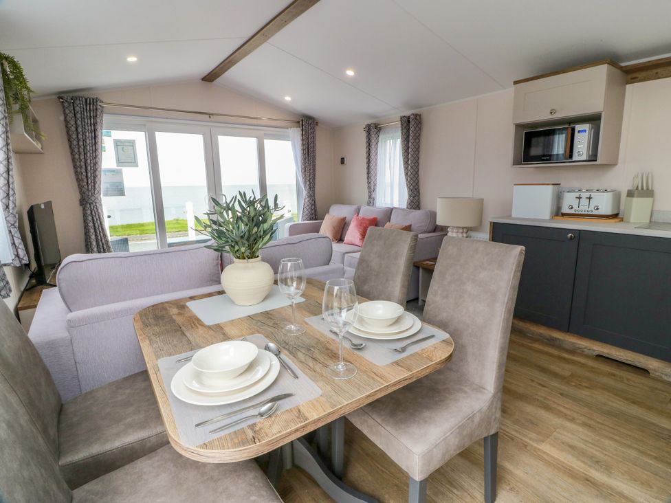 A living room with a sofa and dining table at Caravan in Girvan