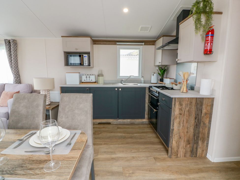 A kitchen with cabinets and appliances at Caravan in Girvan