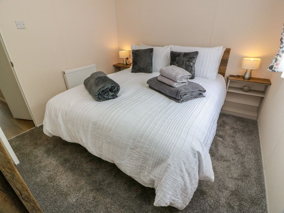 A bedroom with a bed and bedside table at Caravan in Girvan