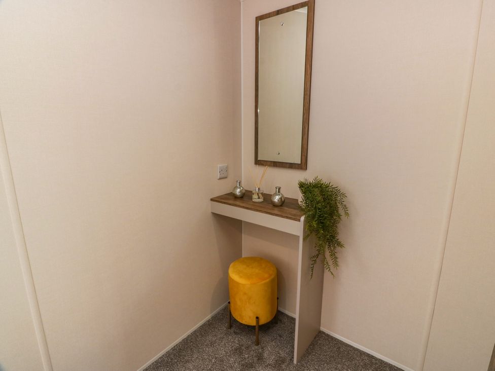 A bathroom with a table and mirror at Caravan in Girvan