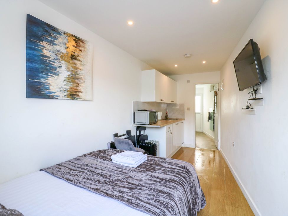 A bedroom with a kitchenette and television at Annex in Southend-On-Sea