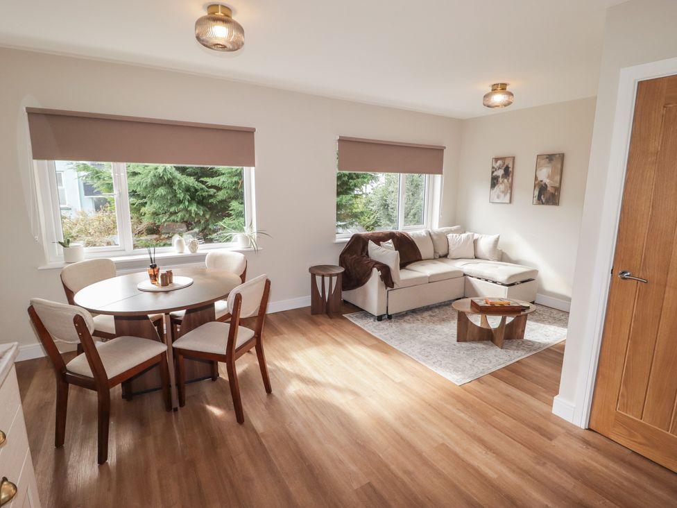 A living room with a sofa and dining area at Flat 4 in Tenby