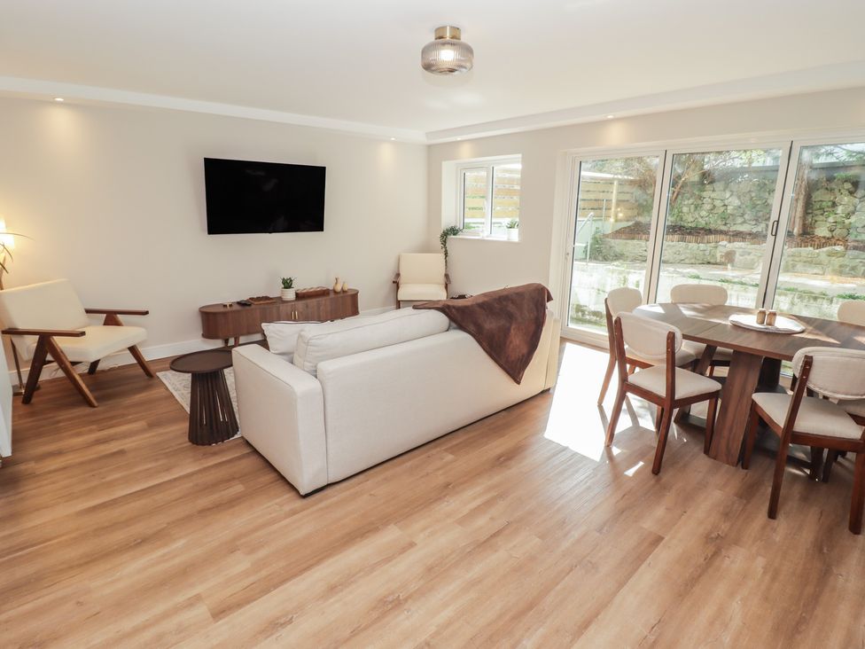 A living room with a sofa and dining area at Flat 1 in Tenby
