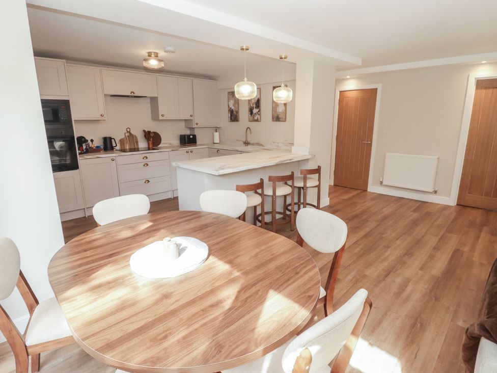A kitchen with a round table and chairs at Flat 1 in Tenby