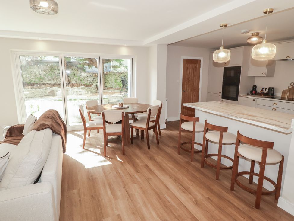 A living room with a dining table and kitchen counter at Flat 1 in Tenby
