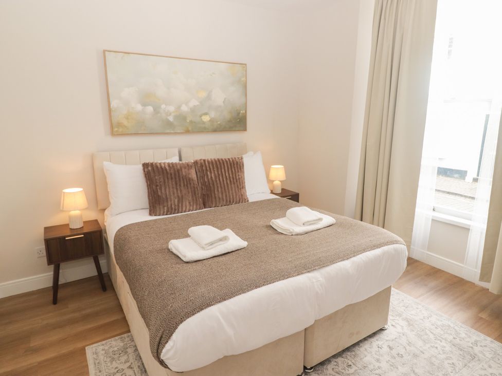 A bedroom with a double bed and nightstands at Flat 1 in Tenby