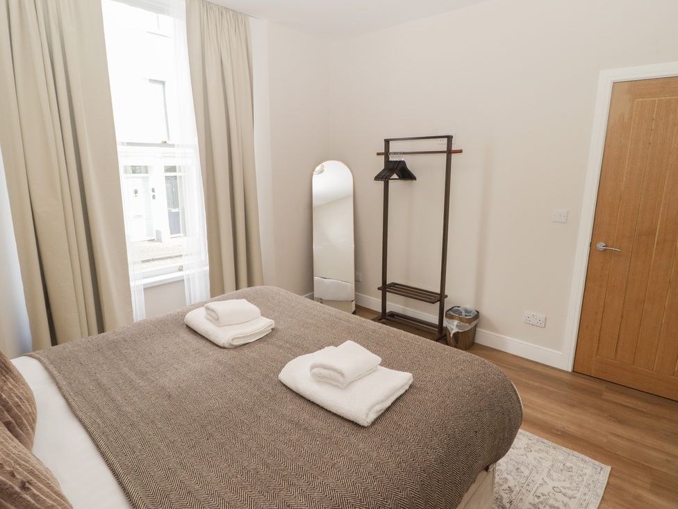 A bedroom with a bed and towels on top at Flat 1 in Tenby