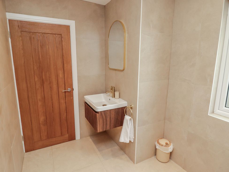 A bathroom with a sink and a mirror at Flat 1 in Tenby