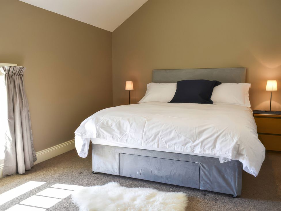 A bedroom with a bed and bedside lamps at The Hayloft in Hexham