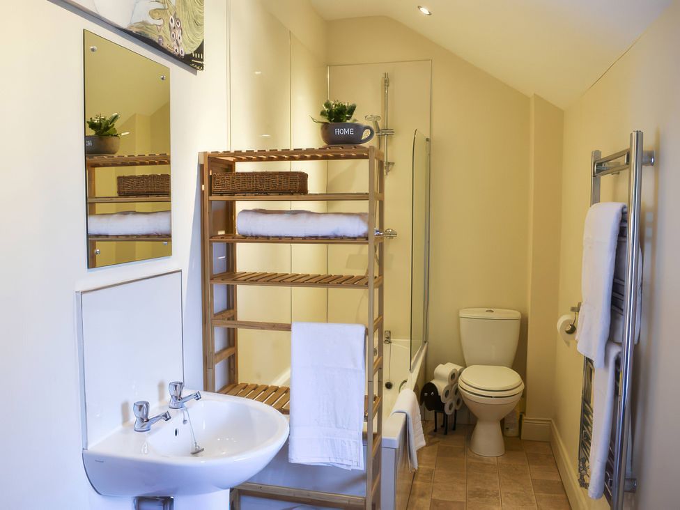A bathroom with a sink, toilet, and shower at The Hayloft in Hexham