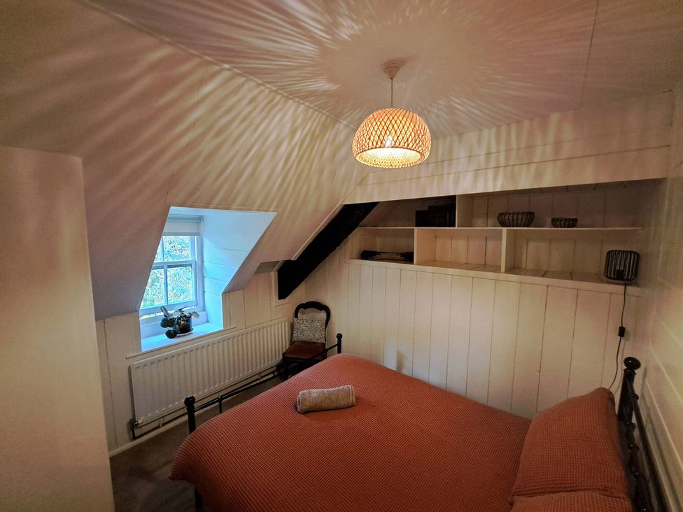 A bedroom with a bed and chair at Y Cwtch in Dolgellau