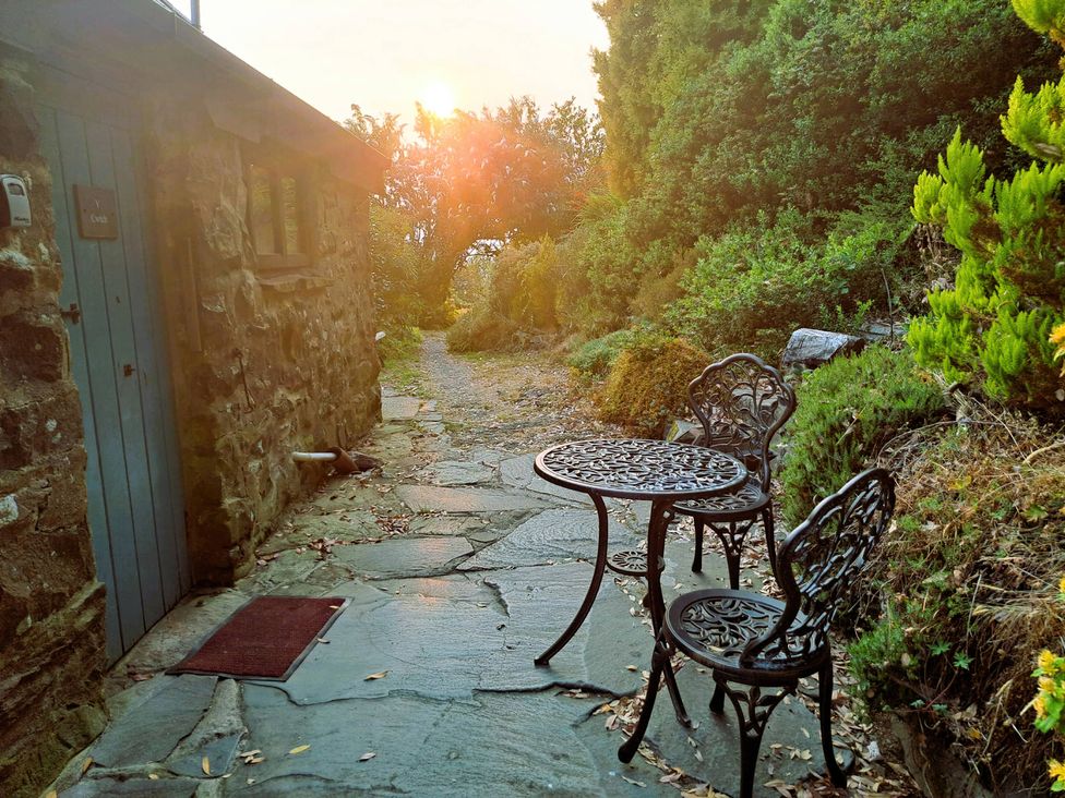 An outdoor area with a stone pathway and a small table with two chairs at Y Cwtch in Dolgellau