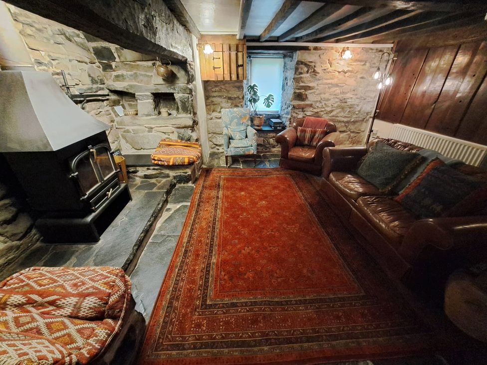 A living room with a fireplace and seating area at Y Cwtch in Dolgellau