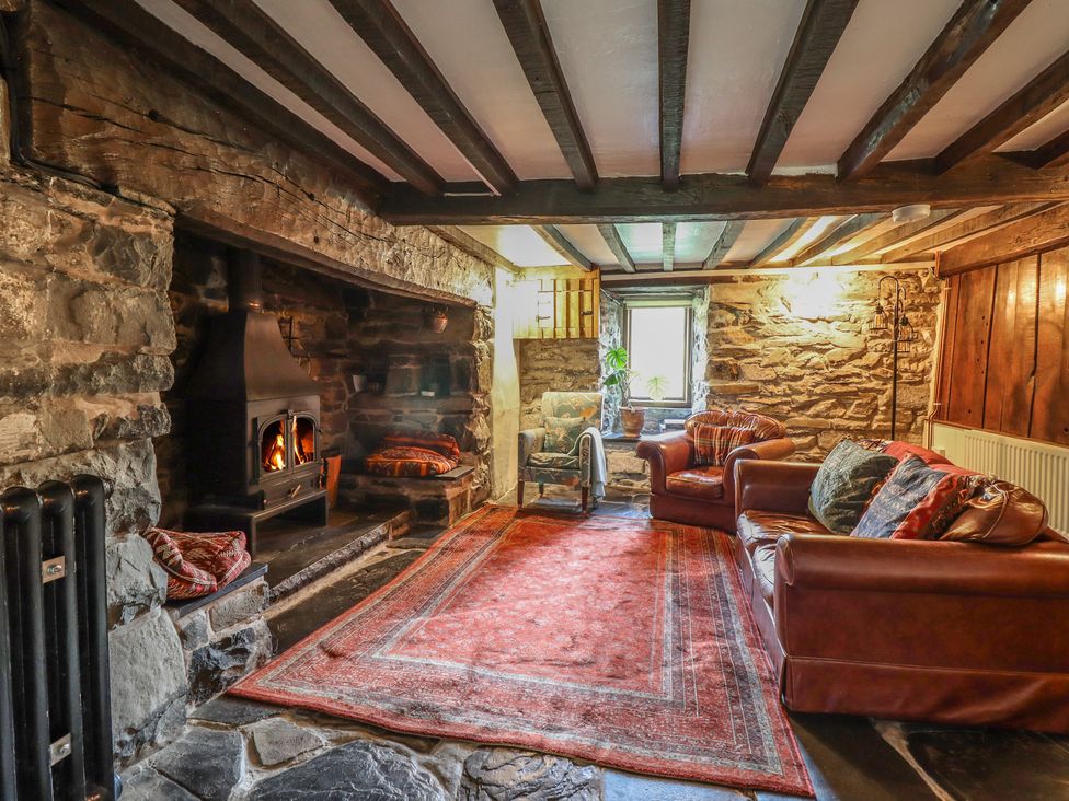 A living room with a fireplace and sofas at Y Cwtch in Dolgellau